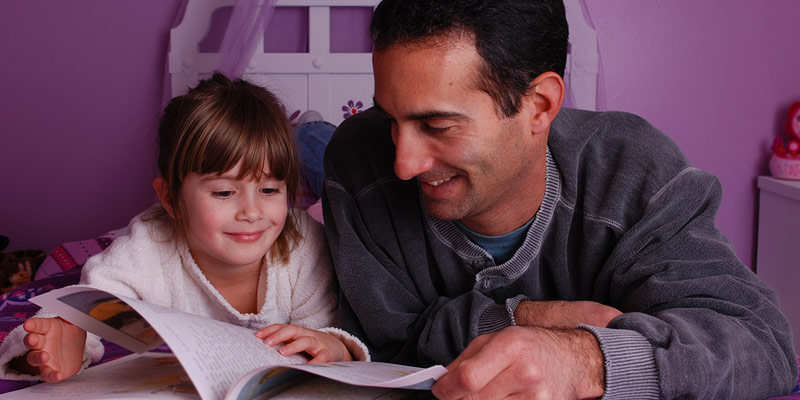 A father and daughter reading together